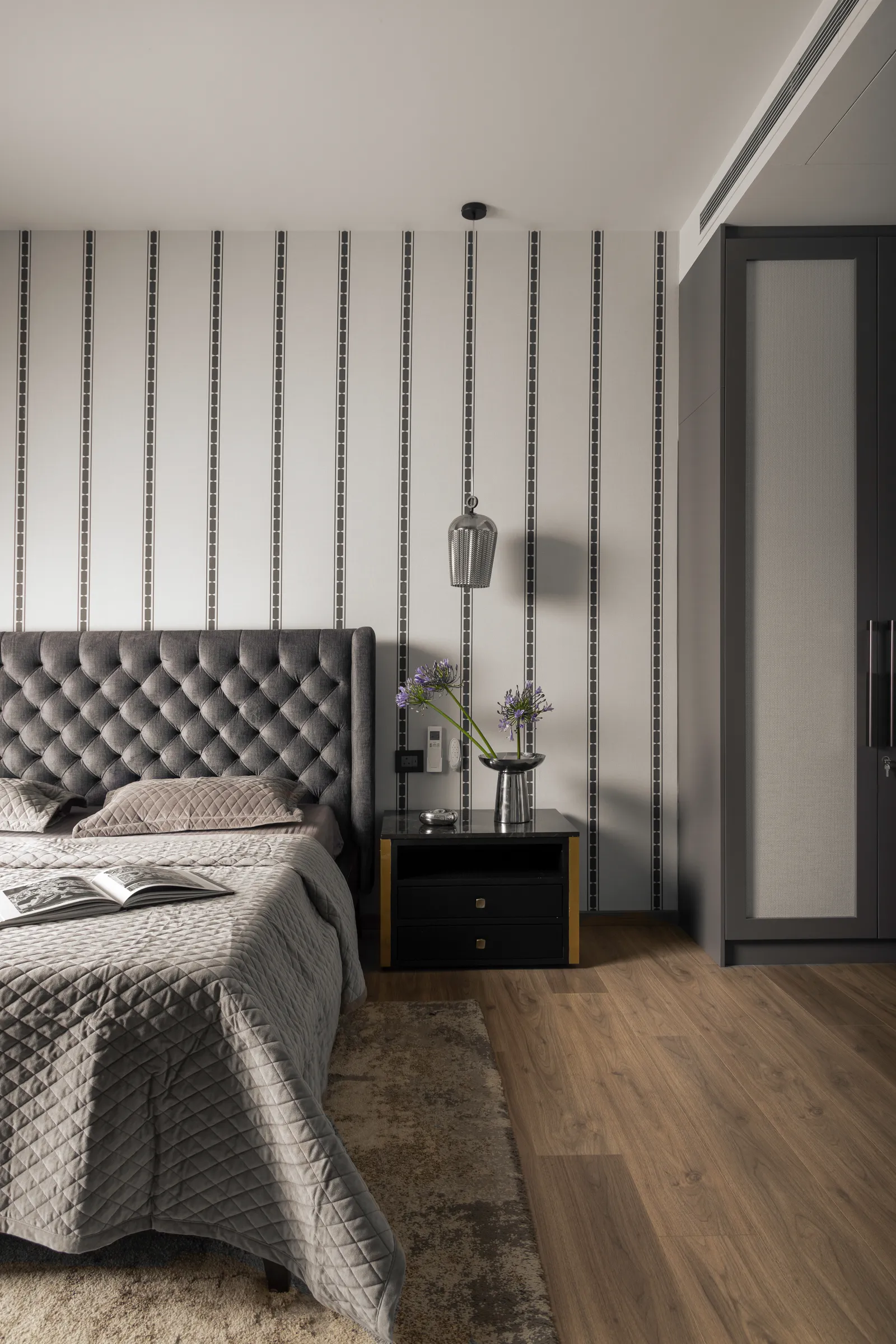 Bedroom with tufted grey headboard and striped wall — Seema Katta Svasa